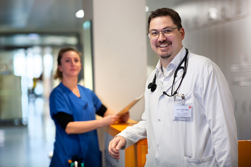 Ein Arzt und eine Ärztin im Flur der Klinik