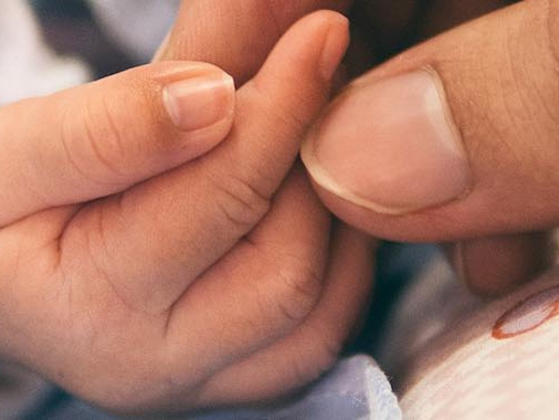 Hand eines Babys in der Hand seiner Mutter