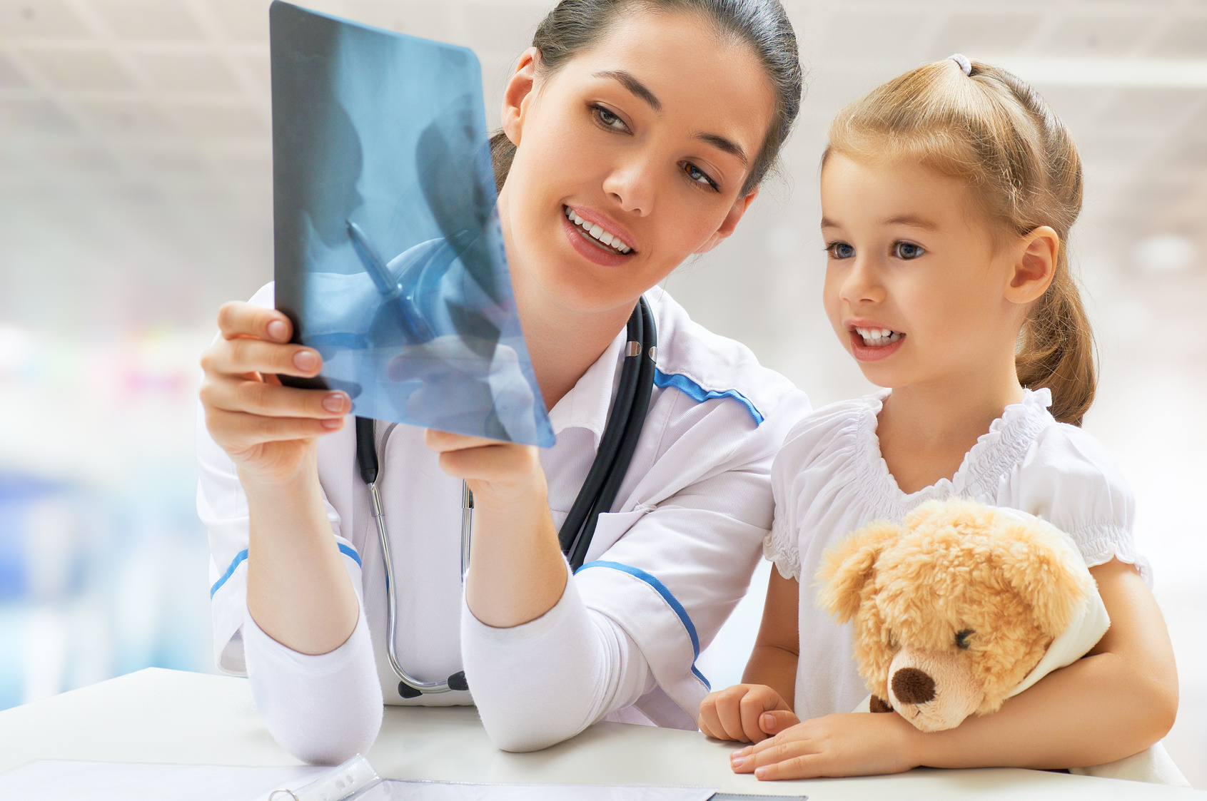 Ärztin zeigt Mädchen eine Röntgenaufnahme