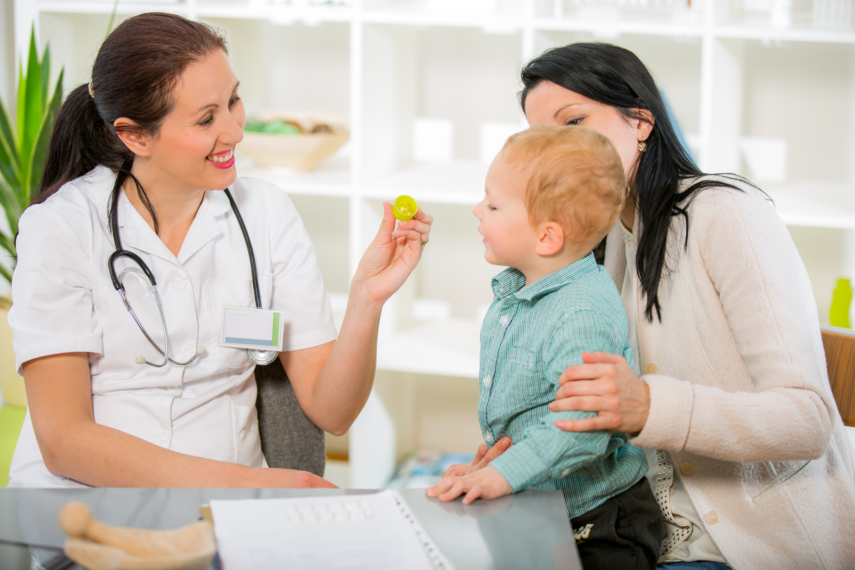 Ärztin spricht mit Kind und Mutter