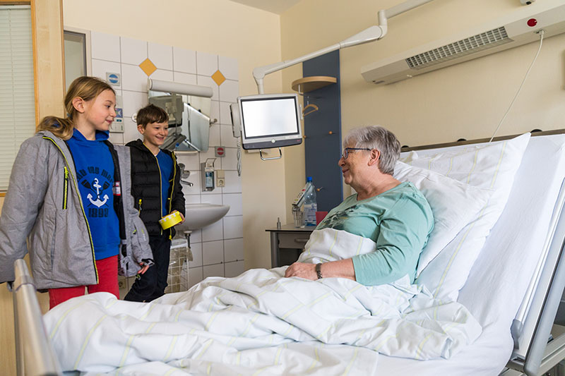 Kinder am Krankenbett ihrer Oma