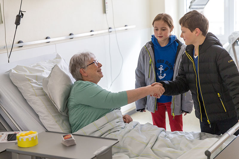 Frau schüttelt Kind die Hand